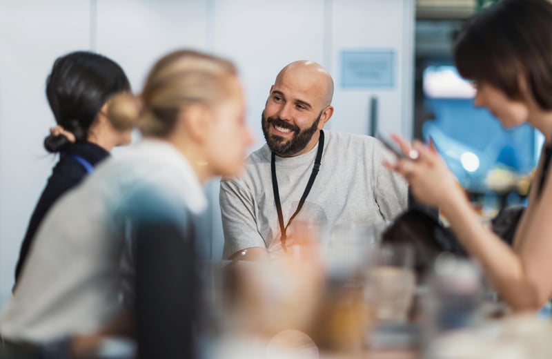Group of people around a table speaking 